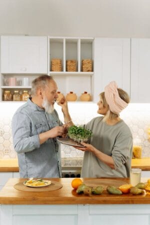 Couple preparing a healthy meal together in the kitchen, symbolizing meal prep for balance and wellness.