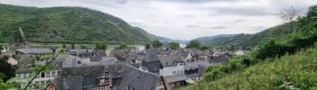 Scenic view of Bacharach, Germany, with half-timbered houses, vineyards, and the Rhine River surrounded by green hills