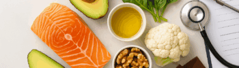 Brain-healthy keto-Mediterranean foods including salmon, avocado, walnuts, olive oil, leafy greens, and dark chocolate.