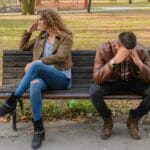 A couple sitting apart after an argument, symbolizing conflict in relationships.